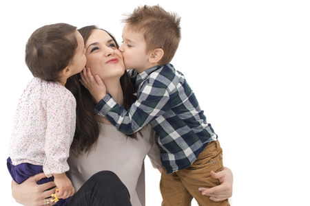 little girl and boy kissing their motherの写真素材