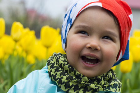 portrait of a beautiful little girl with tulips in background