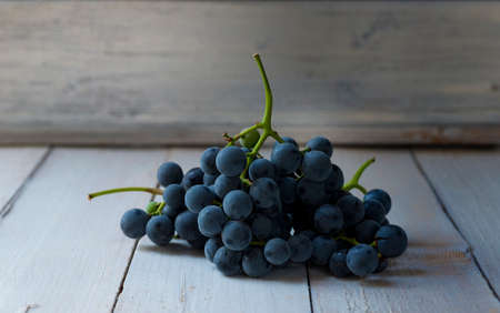 bunch of blue grapes on wooden backgroundの写真素材