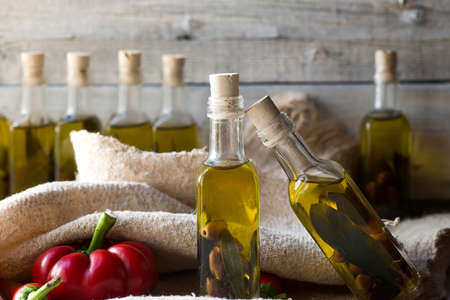 olives and olive oil in mini bottle on wood tableの写真素材