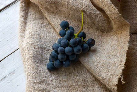 bunch of blue grapes on wooden background and clothの写真素材