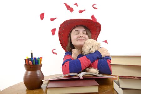 young girl with red hat loving her teddy bearの写真素材