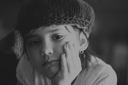 Portrait of beauty school aged brunette kid girl with black eyes indoor in black and white edition