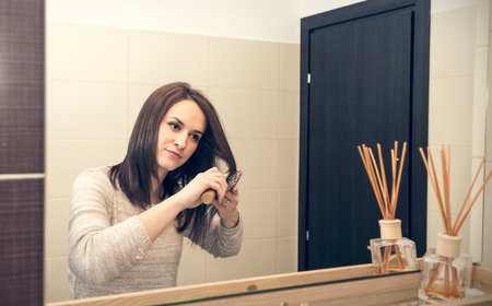 young woman arranging herself in the bathroom in the morningの写真素材
