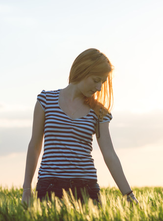 blonde girl in the green field enjoying natureの写真素材