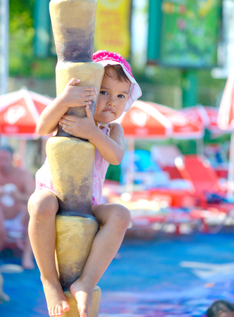 Smiling child climbing a  tree. fake palm at aqua parkの写真素材