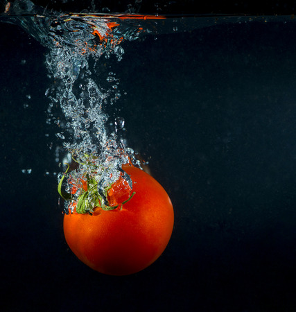 high speed photography tomato splash in waterの写真素材
