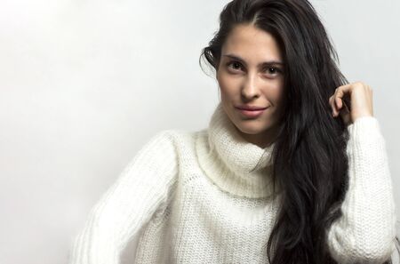 Beautiful brunette woman intense close up portrait on white background.の写真素材