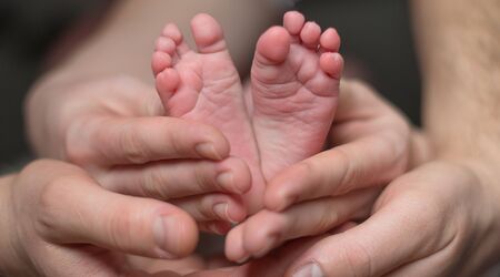 Cute baby legs in the parents hands