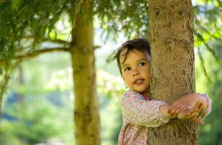 Little girl hugging the treeの写真素材
