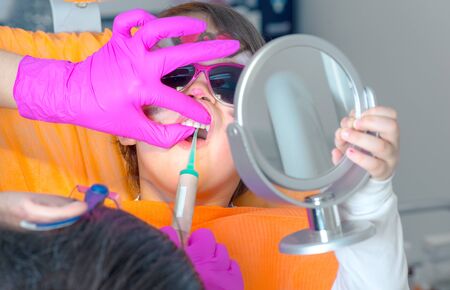Little cute girl sitting in chair at dentist with sunglasses getting treatment