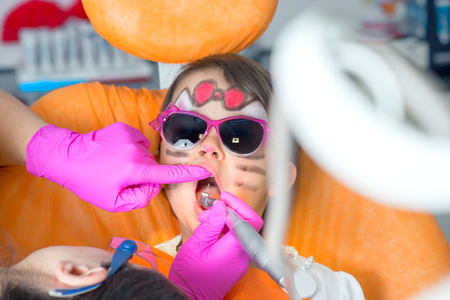 Little cute girl sitting in chair at dentist with sunglasses getting treatmentの写真素材