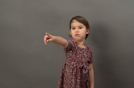 Young little girl pointing finger isolatedの写真素材