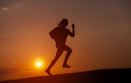Female Runner Silhouette, Running into sunset, colorful sunset skyの写真素材