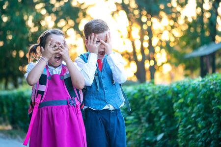 A boy and a girl with backpacks and being afraid of the first day of schoolの写真素材