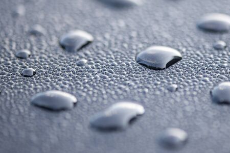 Water drops on a black surface. Macro shot.の写真素材
