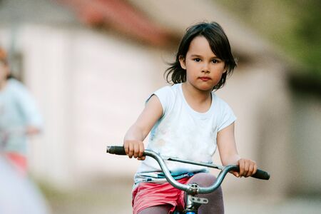 little girl on a bike near the house