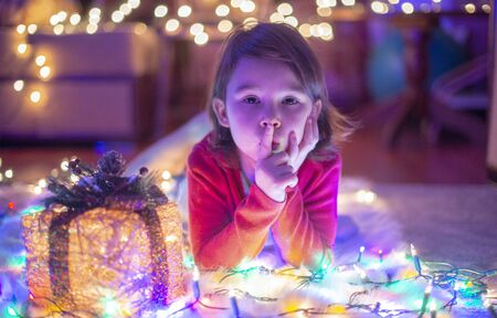little girl withs christmas lights and christmass presentの写真素材