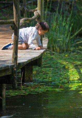 little girl looking at the lakeの写真素材