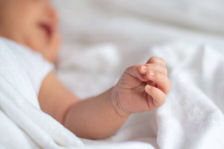 Closeup of an newborn hand when he is on bedの写真素材