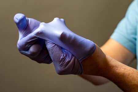 Step of hand throwing away blue disposable gloves medical, Isolated on white background. Infection control concept.の写真素材