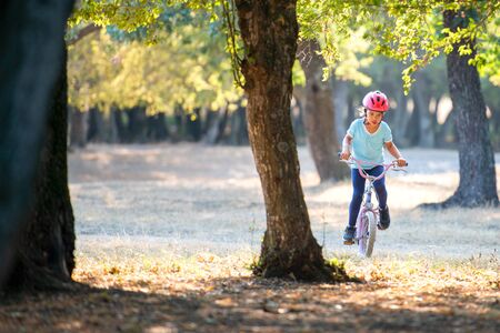 Little girl with biking at sunsetの写真素材