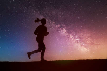 Silhouette of the running girl at nightの写真素材