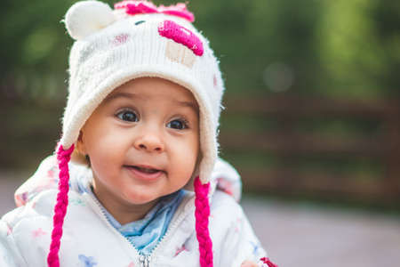 Small adorable infant standing on all fours on wooden floor at home.の写真素材