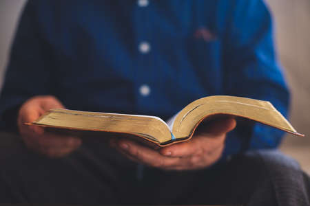 Old Bible in hands of an old man