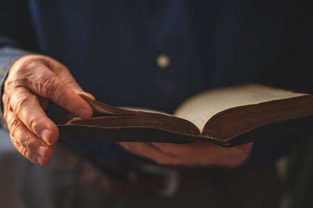 Old Bible in hands of an old manの写真素材
