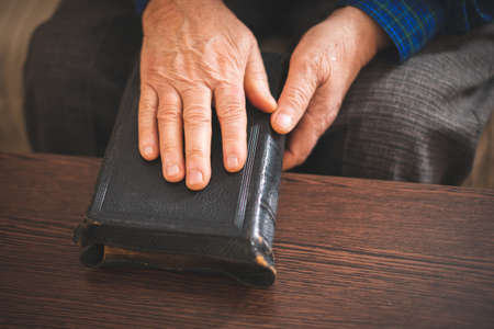 Old Bible in hands of an old manの写真素材