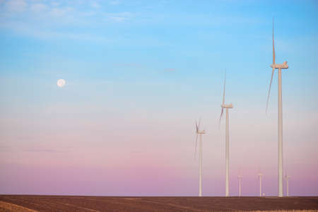 Windmills for electric power production at sunsetの写真素材