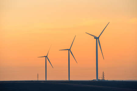 Windmills for electric power production at sunsetの写真素材