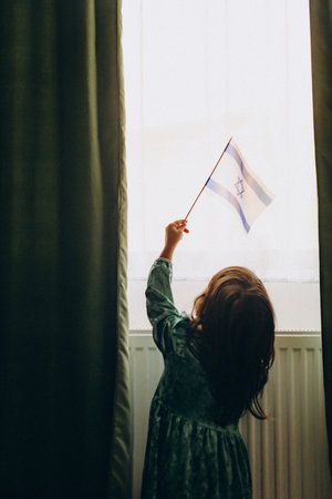 Innocence and Hope: A 4-Year-Old Girl Waving the Israeli Flagの写真素材