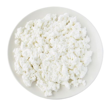 Round plate filled with cottage cheese isolated on white backgroundの写真素材