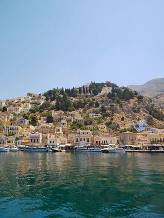 Symi town waterfront with moored motor boats and yachts, Greece.