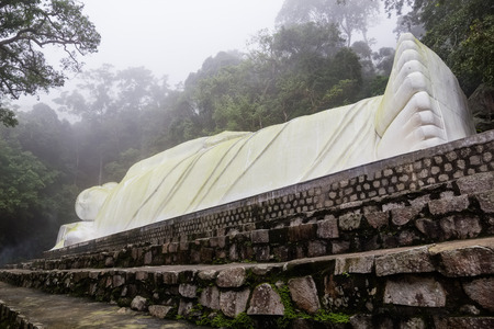 Statue of lying Buddha in the jubgle of Ta Cu mountain, Vietnam. It's one of the biggest statues of lying Buddha in Asia.の写真素材