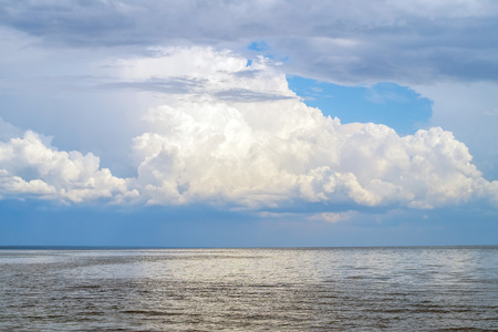 Big lake with big fluffy cloud above nature background.の写真素材