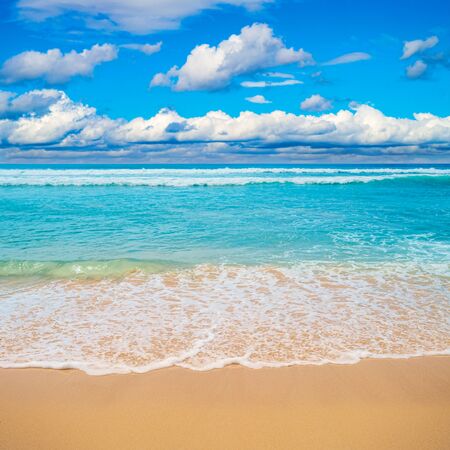 Sea waves white foam over golden beach sand summer background.の写真素材