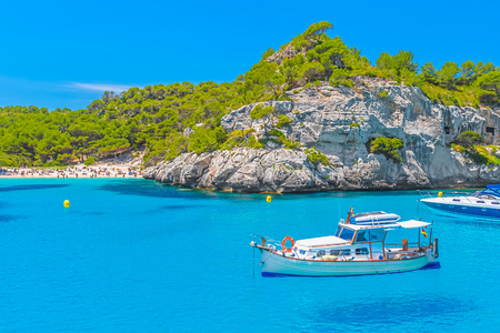 Cala Macarelleta Beach ?ove with Boats Floating on Water at Menorca Island, Spainの写真素材