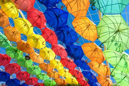 Colorful Umbrellas Hanging in the Air above the City Street. Colorful Summer Background. Rows of Color Umbrellas Protecting from Sunlight.の写真素材