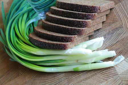 Fresh spring onion and black bread slicesの写真素材