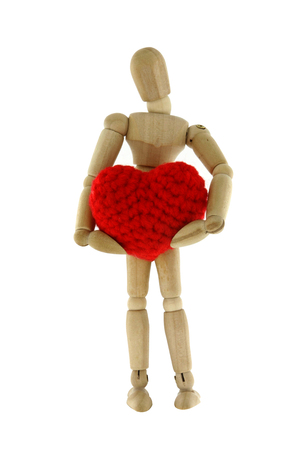 Wooden mannequin holding heart knit with yarn, isolated on white backgroundの写真素材