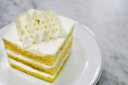 Coconut cake in white dish on marble table.