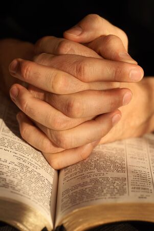 Detail of the Holy Bible opened on Psalm 23 and  hands in prayer