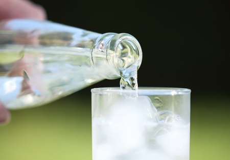 Close-up of bottle with pouring water. Selective focus, shallow DOF.の写真素材