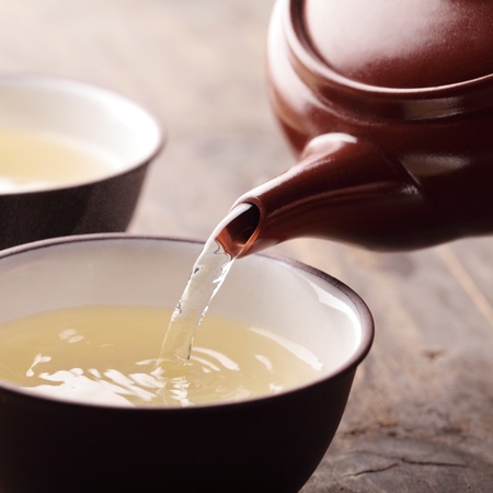 Close-up of teapot ant tea pouring into bowl.の写真素材