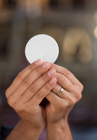 Hands with bread for holy communion.の写真素材