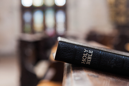 Bible at wooden church bench.