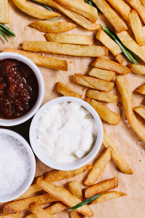 French fries and bowls with salt, lutchup and dip.の写真素材